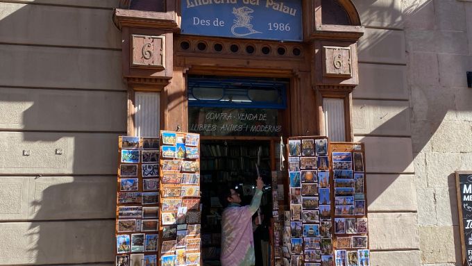 Gessamí Catafau placing the postcards at the entrance of her bookstore. Photo: Línia Ciutat Vella
