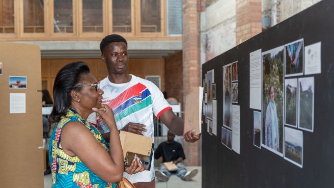 One of the participants of ‘Compartim camins’ shows the exhibition. Photo courtesy
